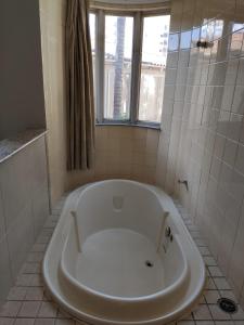 a white tub in a bathroom with a window at Suíte Hot Springs B3 Hotéis Hospedagem - Até 4 adultos in Caldas Novas
