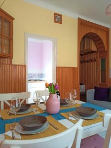 une salle à manger avec une table, des assiettes et des verres à vin dans l'établissement Nárcisz Vendégház, à Mezőkövesd
