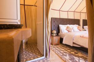 a bedroom with a bed and a tub and a mirror at Sunset luxury camp in Hassilabied