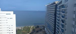 una vista del océano desde dos edificios en Apartamento con salida al Mar, en Santa Marta