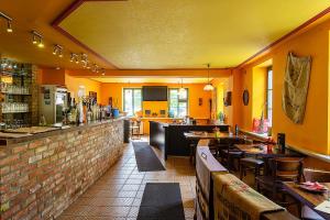 restauracja ze stołami i bar z żółtymi ścianami w obiekcie Ostseehotel Neubukow w mieście Neubukow