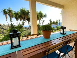 un tavolo su una veranda con vista sulle palme di Gorgeous private Villa with sea view! ad Andro