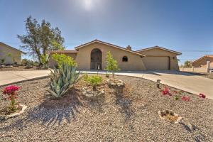 a house with a yard with flowers and a driveway at Homey Lake Havasu Abode An Ideal Boaters Getaway! in Lake Havasu City