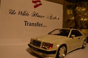 a model of a white car in front of a sign at The White House Austria in Lind ob Velden