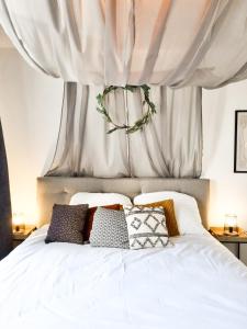 1 dormitorio con cama blanca y cortinas en Holiday Home Amélie, en Bollendorf