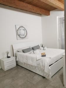 een witte slaapkamer met een bed en een houten plafond bij GINEVRA in La Spezia