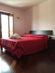 Oleandro Room في سان سيفيرينو لوكانو: غرفة نوم بسرير احمر مع بطانية حمراء