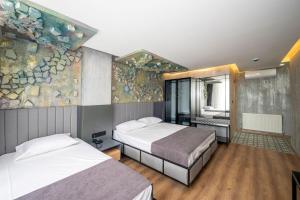 a bedroom with two beds and a stone wall at Continental Airport Hotel in Istanbul