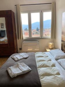 サルザーナにあるB&B Del viaggiatoreのベッドルーム1室(大型ベッド1台、タオル付)