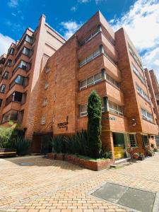 a brick building with a tree in front of it at Hotel Retiro 84 by MIJ in Bogotá