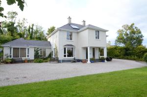 una gran casa blanca con una entrada de grava en Haywoods B&B, en Donegal