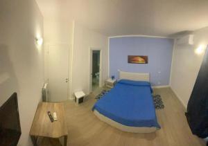 a bedroom with a blue bed and a table at Riviera Albachiara Anzio B&B in Anzio