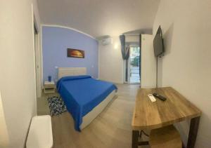 a bedroom with a bed and a wooden table at Riviera Albachiara Anzio B&B in Anzio