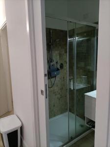 a glass shower in a bathroom with a toilet at Riviera Albachiara Anzio B&B in Anzio