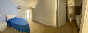 a bedroom with a bed with a blue sheet on it at Riviera Albachiara Anzio B&B in Anzio