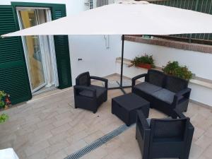 a patio with two chairs and an umbrella at Riviera Albachiara Anzio B&B in Anzio