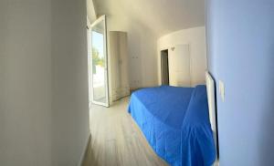 a bedroom with a blue bed and a mirror at Riviera Albachiara Anzio B&B in Anzio
