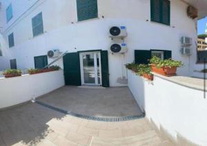 a white building with a door and a patio at Riviera Albachiara Anzio B&B in Anzio