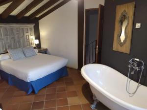 HitaにあるSpa La Cueva del Aguaのベッドルーム1室(ベッド1台、バスタブ、ベッド1台付)