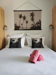Un dormitorio con una cama blanca con palmeras. en Habitation I'SEO Adult Only en Sainte-Anne