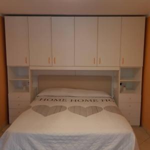1 dormitorio con 1 cama con armarios blancos en Le tue vacanze a Varzo, appartamento il girasole. en Varzo