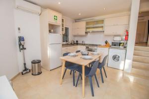 cocina con mesa de madera y sillas en Sunny villa by the beach surrounded by pine trees, en Vale do Lobo