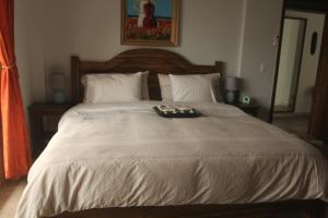 Una cama grande con una bandeja encima. en El Ocaso en Canoa