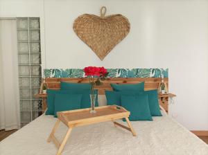 a table with a vase of flowers on a bed with a heart at Beautiful beach in Santa Cruz de Tenerife