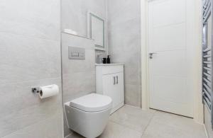 a white bathroom with a toilet and a mirror at Elegant Central, Private Parking, Leisure, Contractor in Buckinghamshire
