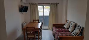 a room with a couch and a table and a window at Departamento Solares - San Martin in Bahía Blanca