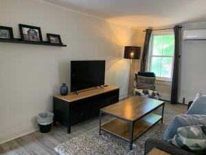 een woonkamer met een tv en een bank en een tafel bij County Cove - Bloomfield Suite in Wellington