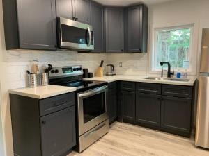 a kitchen with black cabinets and stainless steel appliances at County Cove - Wellington Suite in Wellington