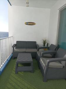 a living room with a couch and chairs on a balcony at Beautiful beach in Santa Cruz de Tenerife