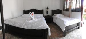 two swans sitting on two beds in a bedroom at Hotel Andino in San Agustín +28 photos