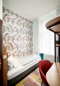 1 dormitorio con cama y pared con papel pintado en AMC Hotel - Schöneberg, en Berlín