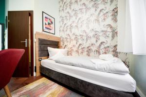 a bedroom with a bed with a floral wallpaper at AMC Hotel - Schöneberg in Berlin