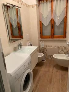 a bathroom with a washing machine and a sink at Villa LINA in Lido Di Fondi