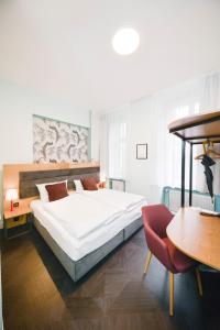 1 dormitorio con 1 cama, 1 mesa y 1 silla en AMC Hotel - Schöneberg, en Berlín