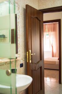 a bathroom with a sink and a mirror and a door at La casa dell'arte in Naples