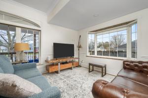 uma sala de estar com um sofá e uma televisão de ecrã plano em Marina and Main em Wellington