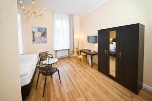 une chambre avec un lit, une table et un bureau dans l'établissement Arco Smart City Hotel - Berlin KU'DAMM, à Berlin