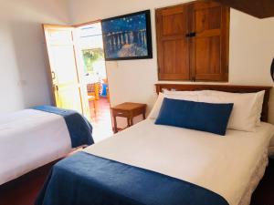 1 Schlafzimmer mit 2 Betten und einer Tür zu einer Terrasse in der Unterkunft Castillo de Cascadas Finca Hotel in Salamina