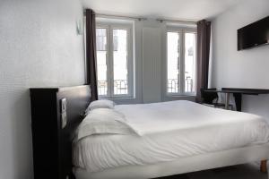 una camera da letto con un grande letto bianco e due finestre di Hotel Mimosa Paris a Parigi