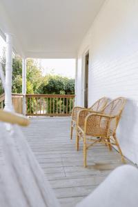 dos sillas de mimbre sentadas en un porche en Wild Rose, en Picton