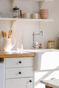 una cocina con armarios blancos y fregadero en Wild Rose, en Picton