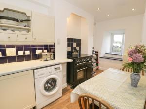 a kitchen with a washer and dryer and a table at Groes Newydd in Llandecwyn