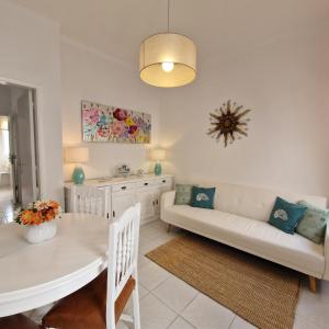 a living room with a white table and a couch at Casa Alzira By ALzira in Albufeira