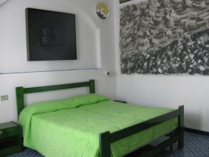 una camera con un letto verde di Museo Albergo d'Arte Contemporanea Atelier Sul Mare a Castel di Tusa