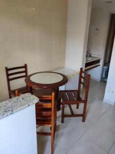 a kitchen with a table and two chairs and a counter at Suíte Hot Springs B3 Hotéis Hospedagem - Até 4 adultos in Caldas Novas