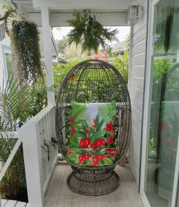 a bird cage sitting on a porch with a pillow at Paradise Cottage at Anthurium Hale in Hilo